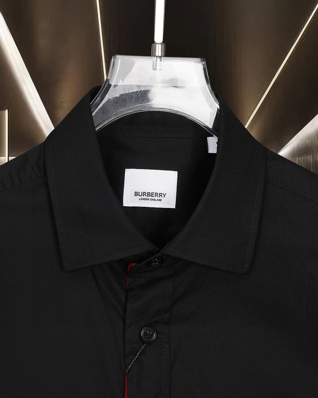 Burberry long-sleeve shirt collar close-up with branded tag, dark black