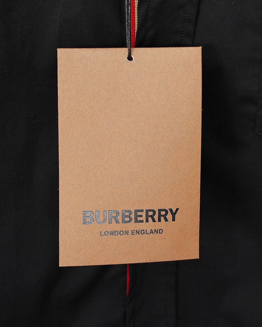 Burberry clothing tag on dark black long-sleeve shirt, London England