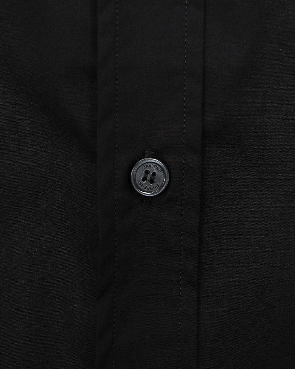 Burberry long-sleeve shirt cuff button close-up, dark black