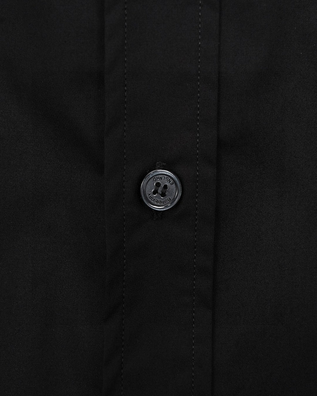 Burberry long-sleeve shirt cuff button close-up, dark black