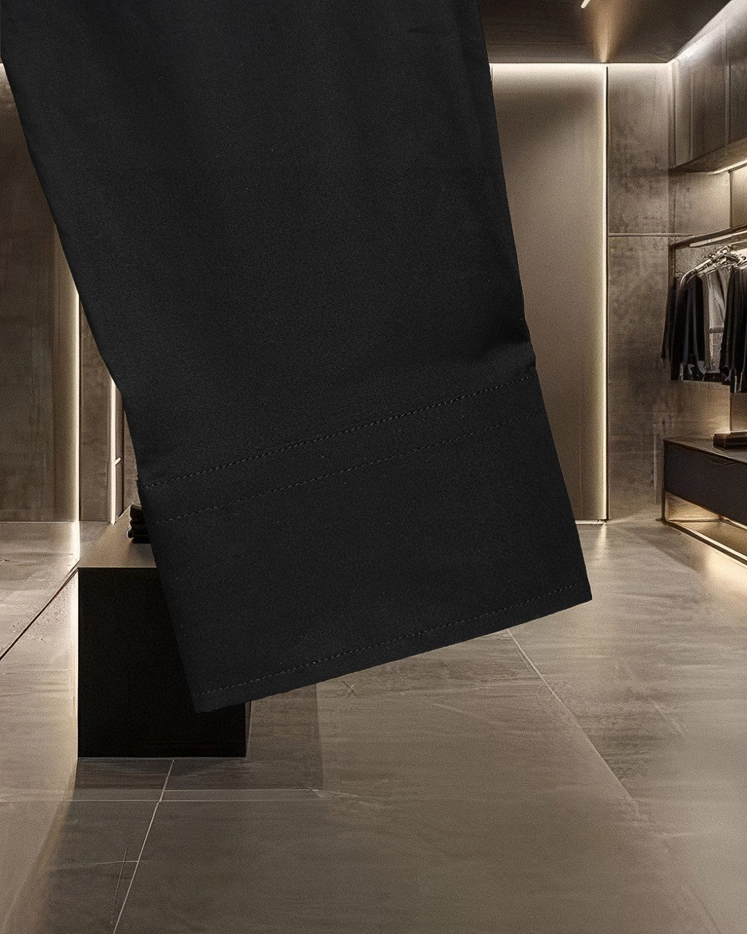Black long-sleeve button-up shirt hem with stitched bottom seam