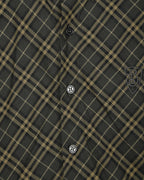Burberry plaid button-up shirt detail, dark green fabric with yellow grid and crest patch