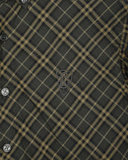 Plaid button-up shirt detail, dark green and yellow grid, crest embroidery near chest