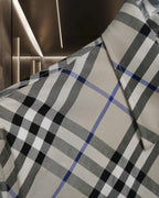 Long-sleeve check shirt fabric close-up, white with black and blue plaid pattern
