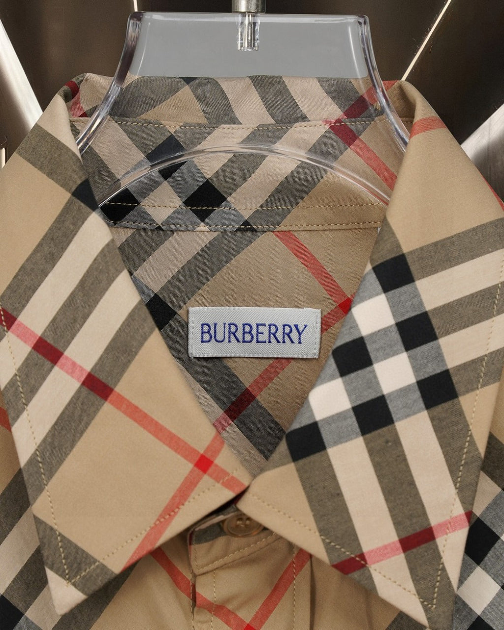 Burberry plaid shirt neckline and logo label on beige fabric with black, red, and gray checks