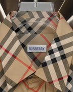 Burberry plaid shirt neckline and logo label on beige fabric with black, red, and gray checks