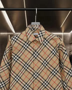 Burberry plaid button-up shirt close-up: pointed collar and button placket on beige base