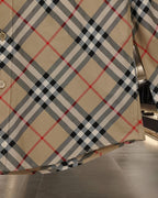 Burberry plaid shirt hem with beige, black, and red checks and button detail
