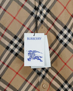 Burberry plaid shirt hang tag on beige fabric with black and red check pattern