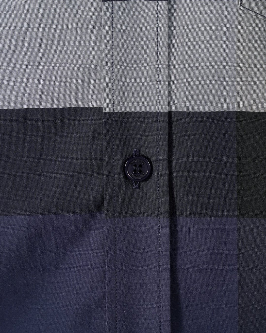 Burberry plaid shirt close-up of stitched placket and dark button on navy check