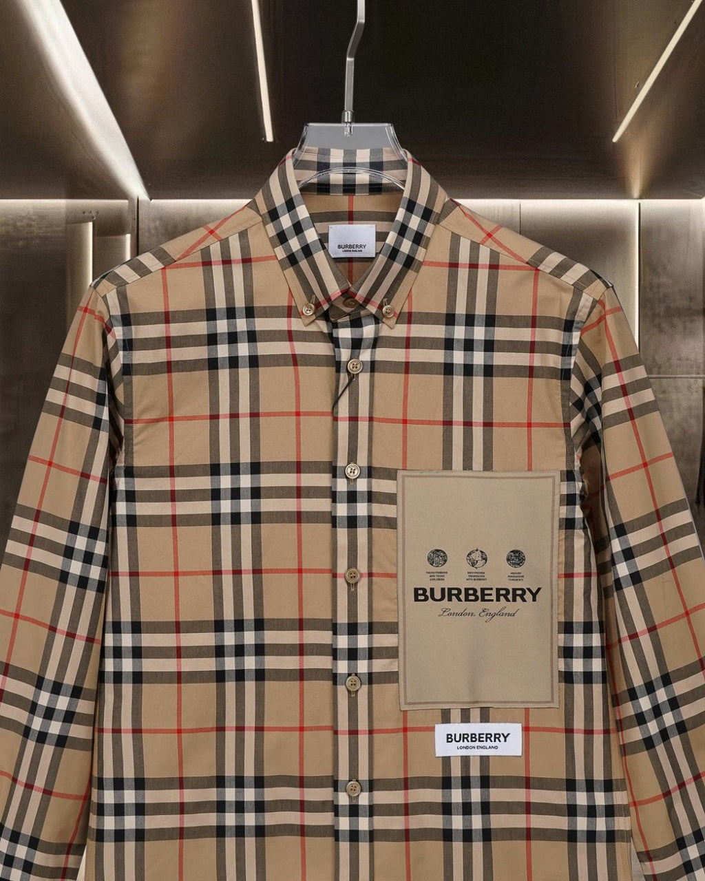 Long-sleeve plaid button-up shirt with chest pocket and beige logo patch