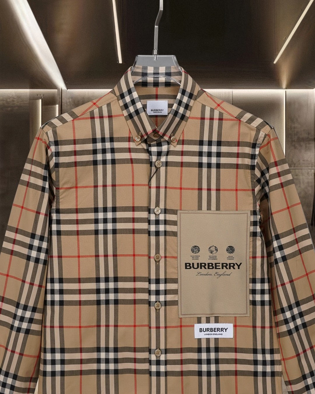 Long-sleeve plaid button-up shirt with chest pocket and beige logo patch