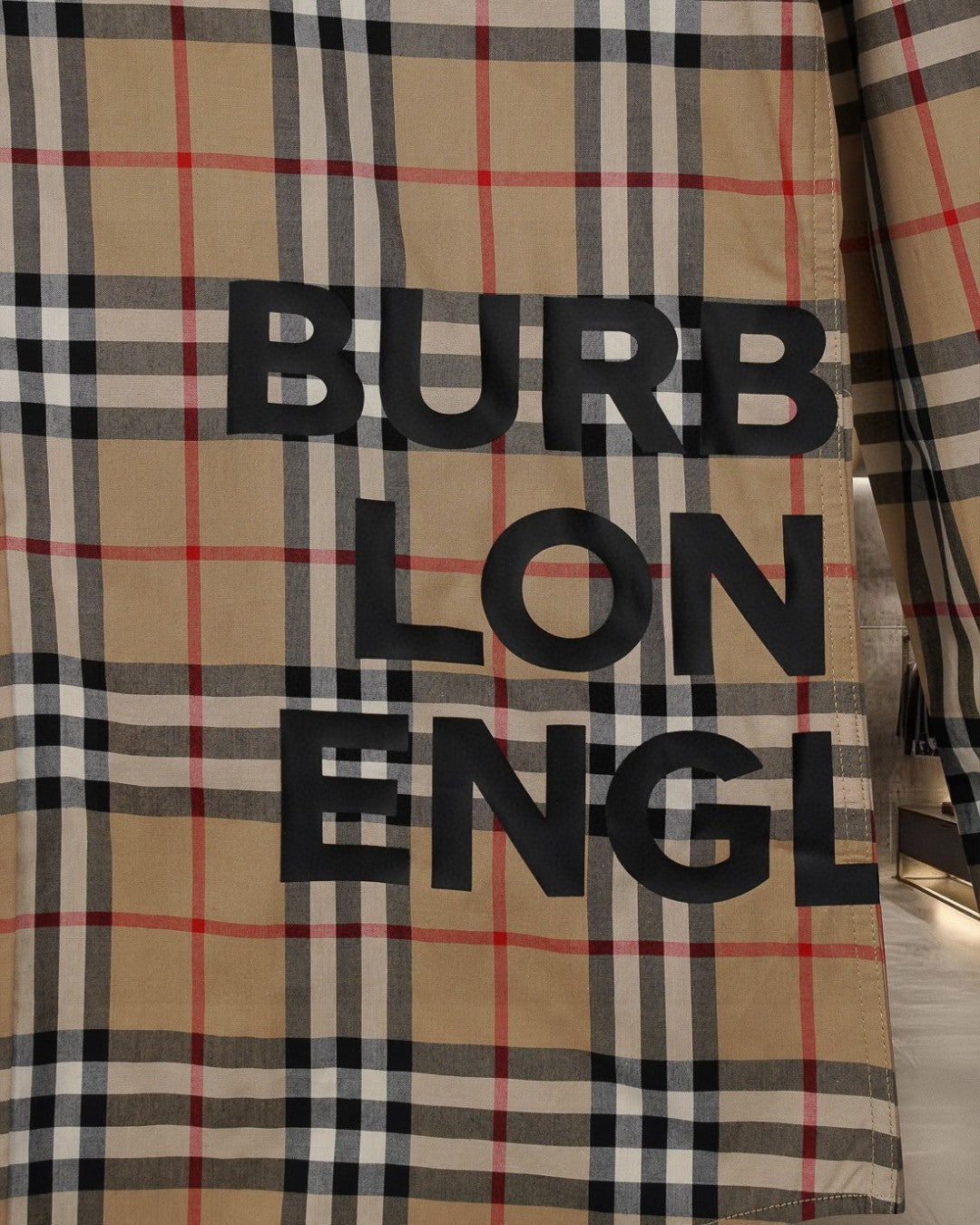 Burberry long plaid coat with large Burberry-style text graphic