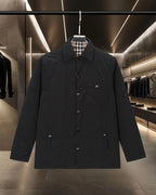 Burberry long coat in black with plaid lining, button front and spread collar
