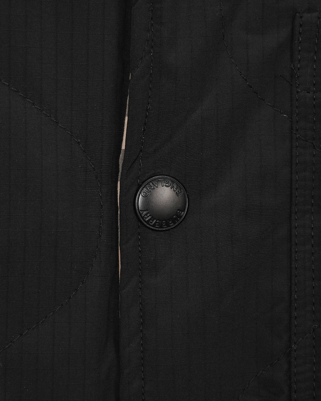 Burberry long coat front with round embossed button on black fabric