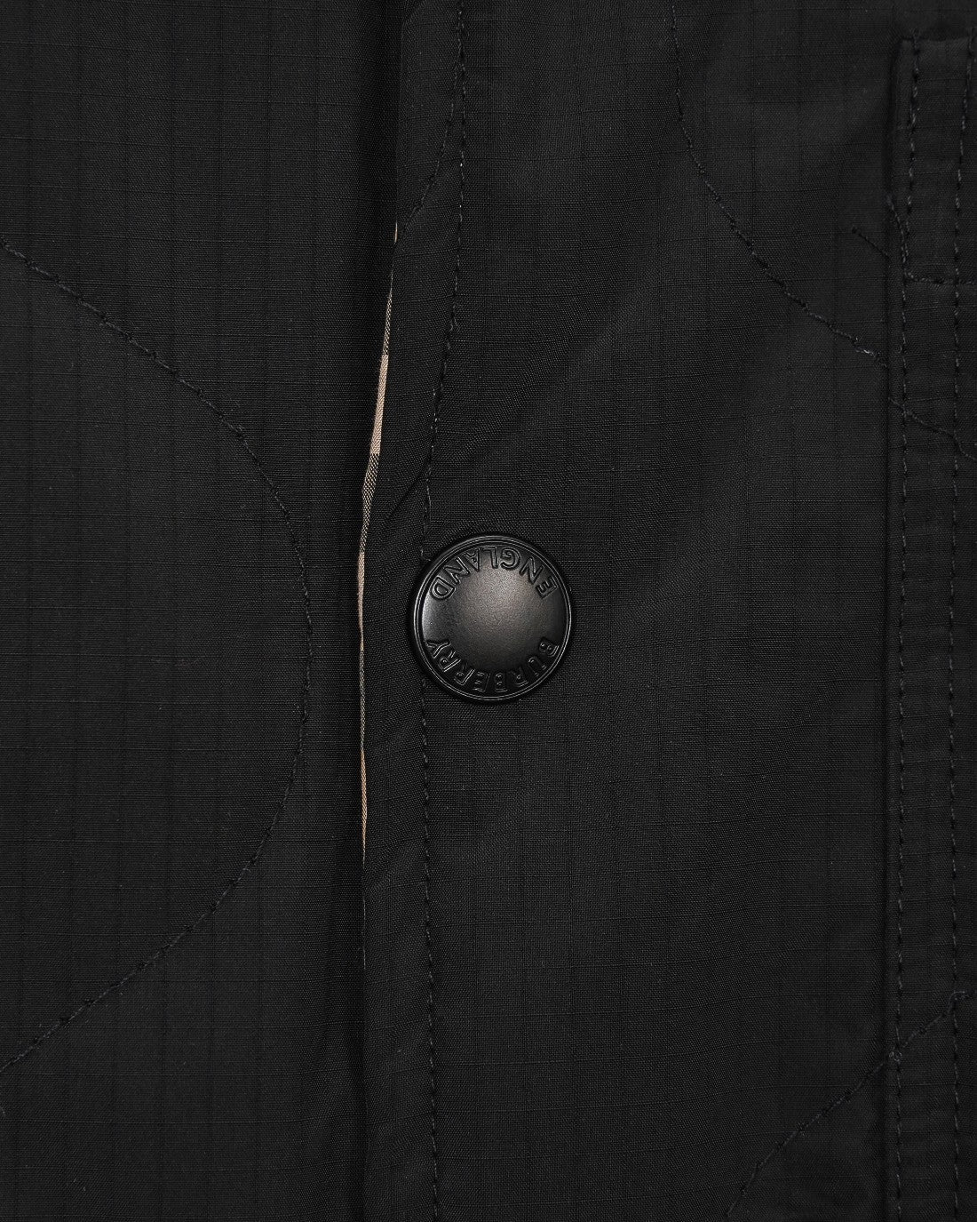 Burberry long coat front with round embossed button on black fabric
