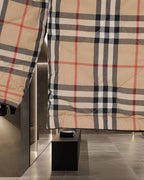 Long plaid coat front and hem with beige, black, and red check pattern and inner lining