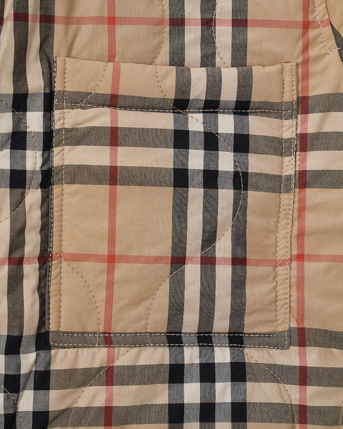 Plaid quilted jacket midsection with rectangular patch stitching and beige, black, and red lines.