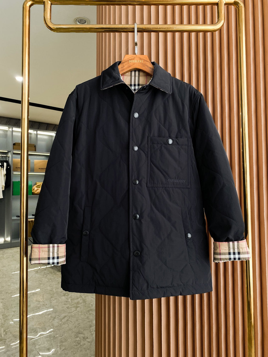 Black long button-up jacket with plaid-lined cuffs and two chest pockets