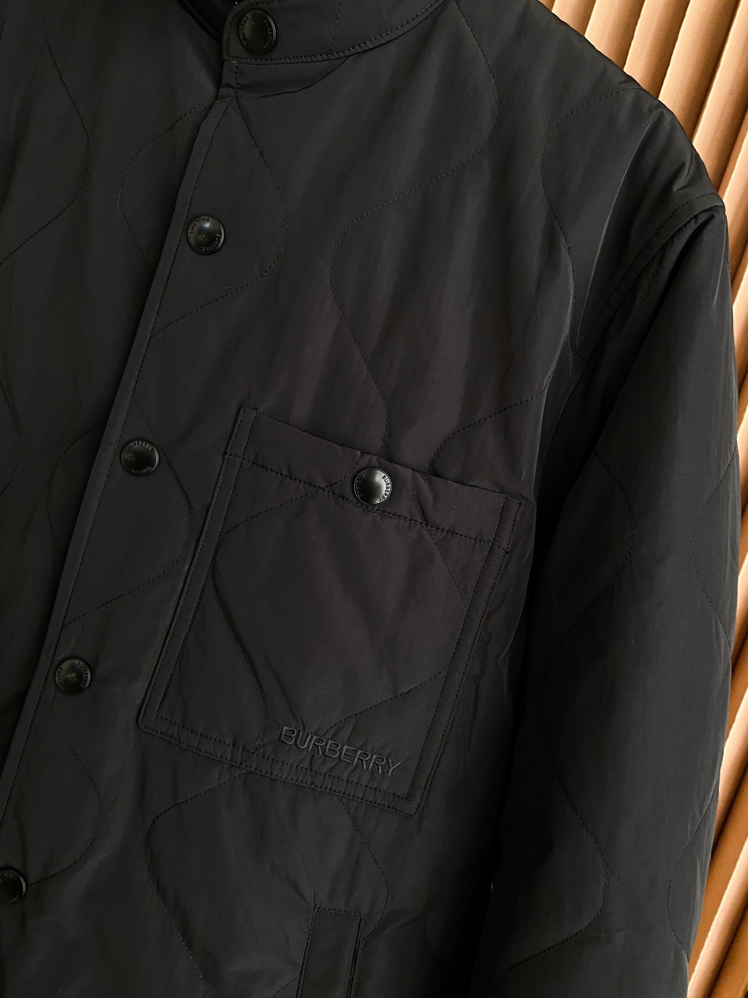 Black jacket with buttoned chest pocket and embossed Burberry logo