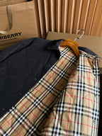 Black long jacket on hanger with tan red and blue plaid inner lining