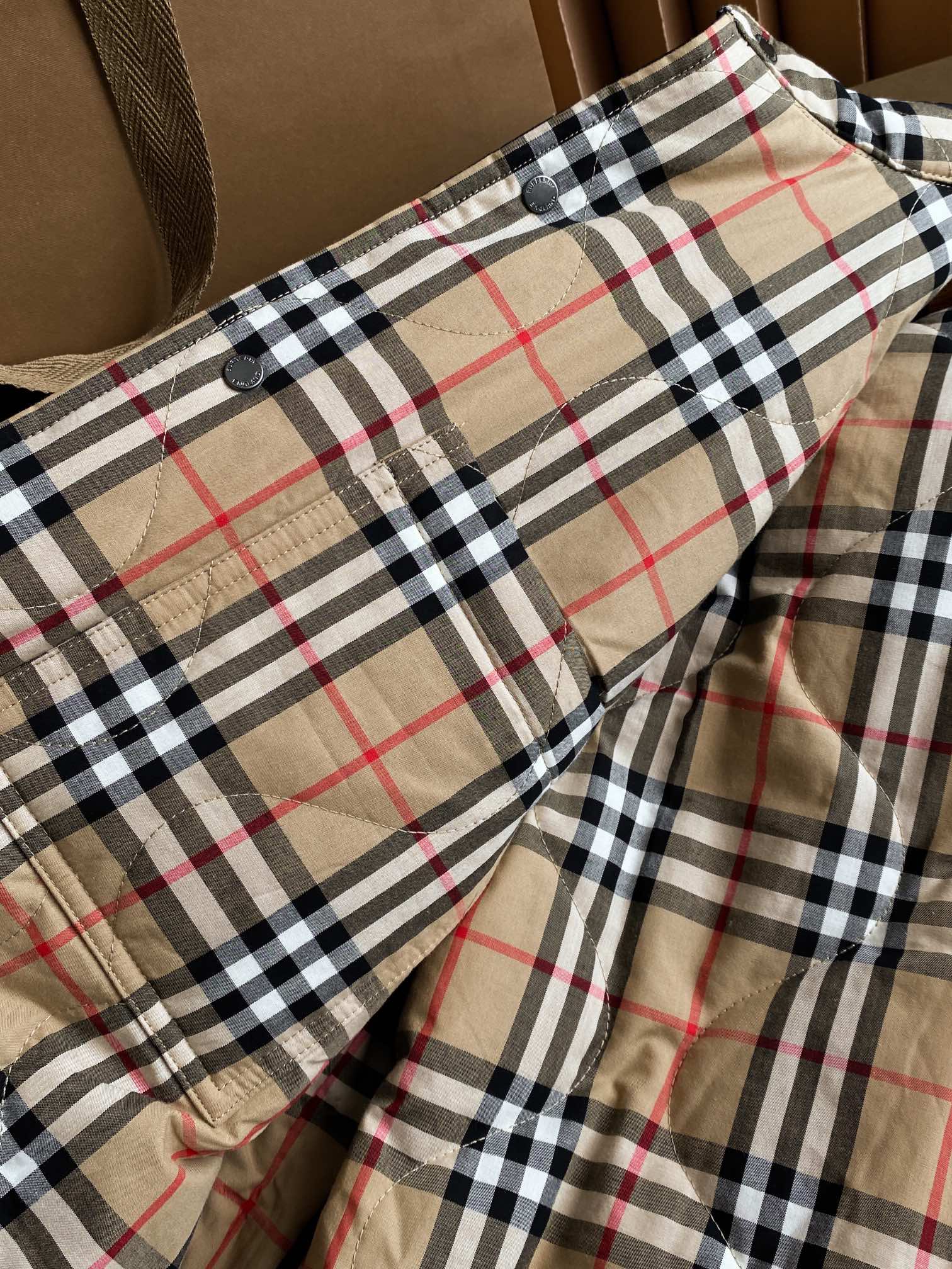 Plaid jacket lining with button detail and gathered side seam