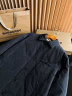Black long quilted jacket close-up of button placket and chest flap pocket