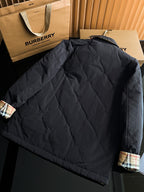 Black quilted long jacket with stand collar and plaid cuff accents