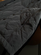 Burberry long quilted coat with diamond stitching, buttoned pocket flap and side seam.