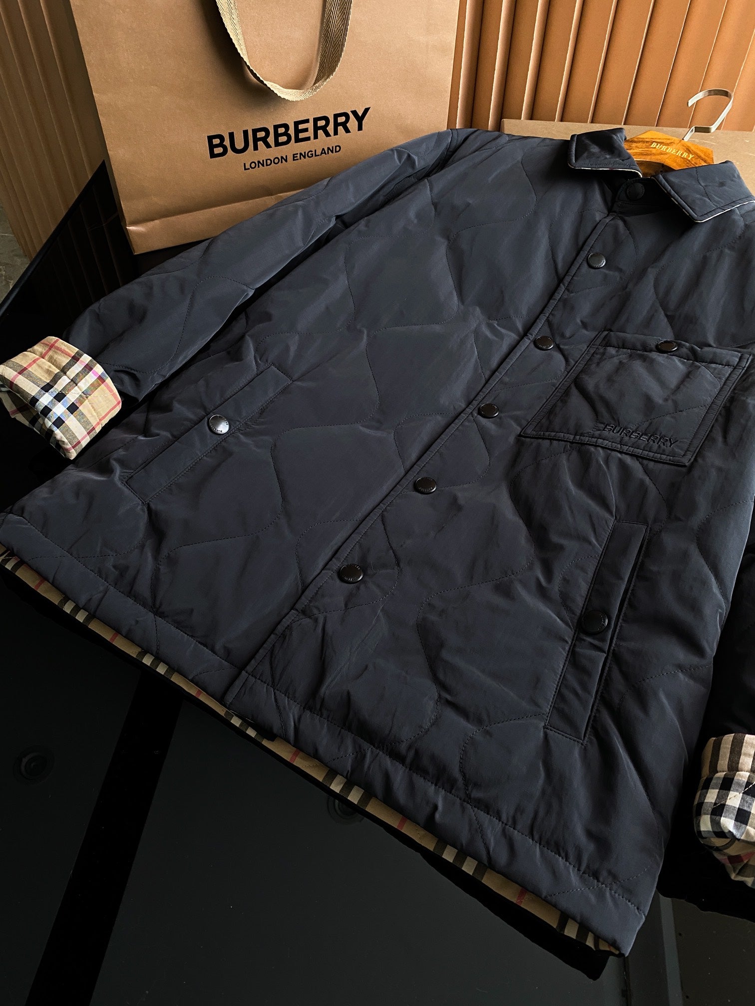 Burberry long quilted coat in dark color, button front, chest pockets and stand collar.