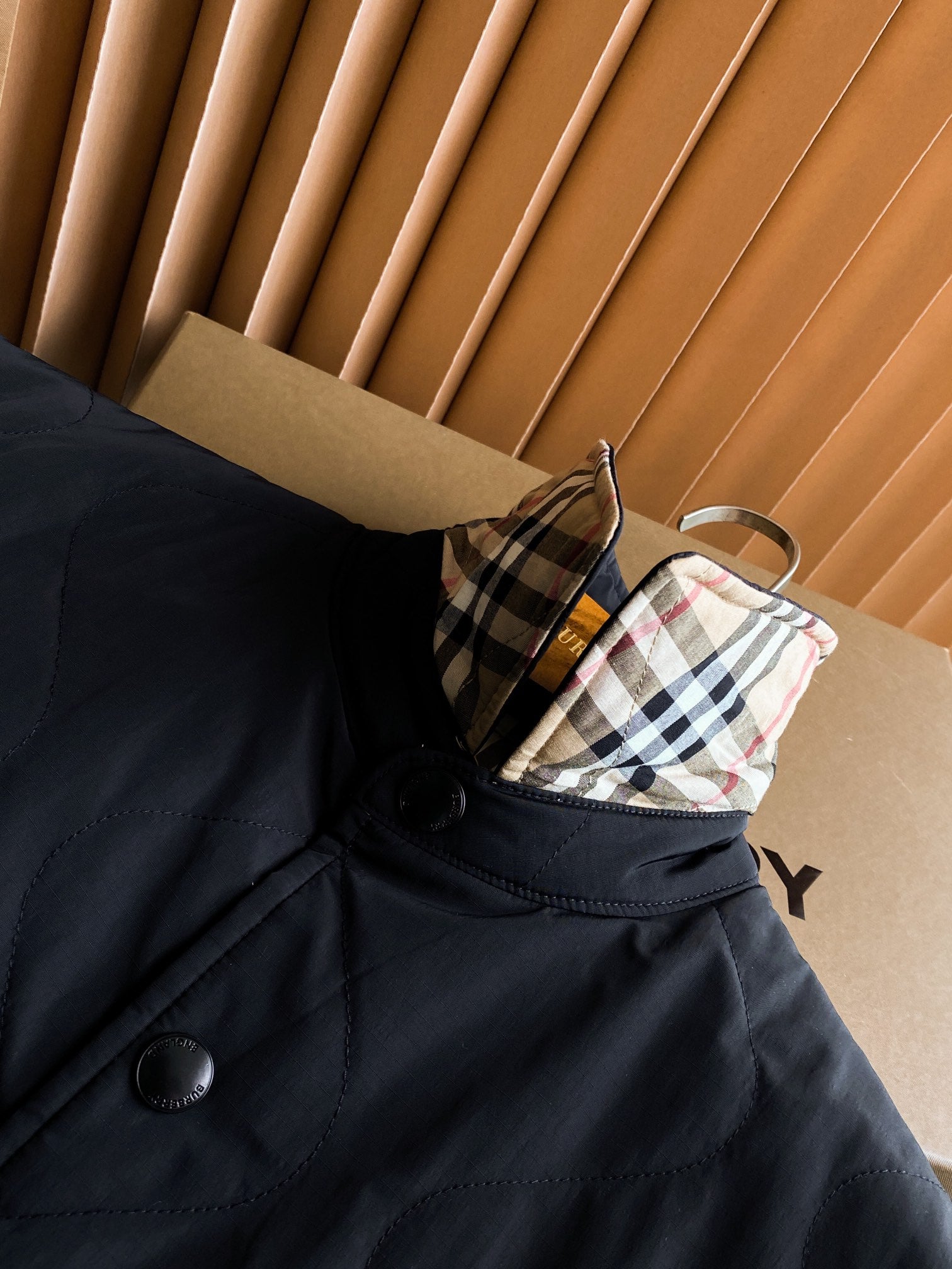 Burberry long coat sleeve cuff with plaid lining detail and buttoned dark front panel.