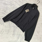 Black Balenciaga zip-up jacket laid flat with front zipper and elastic cuffs.