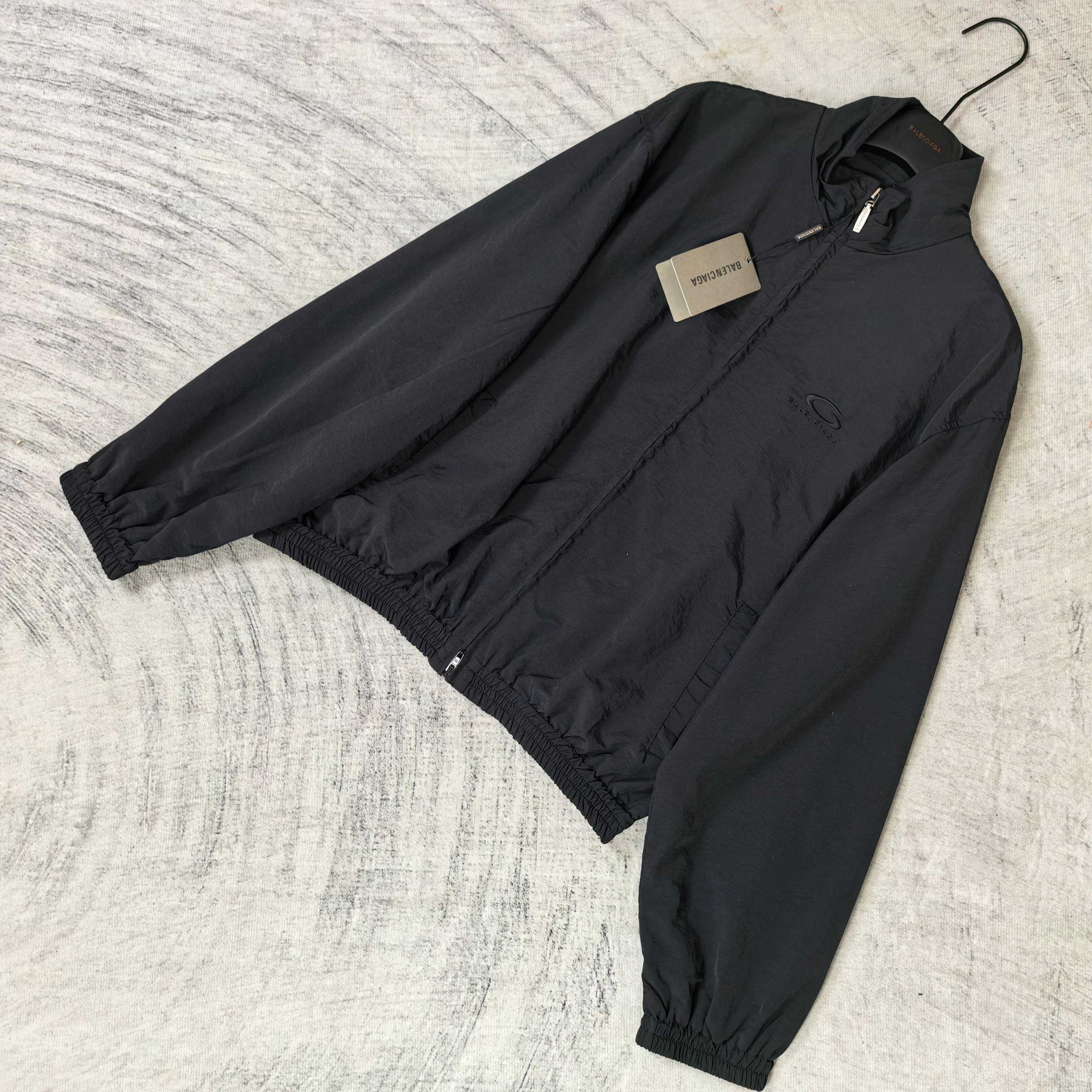 Black Balenciaga zip-up jacket laid flat with front zipper and elastic cuffs.