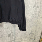 Black zip-up jacket with ribbed elastic hem and cuff, visible lower front zipper.