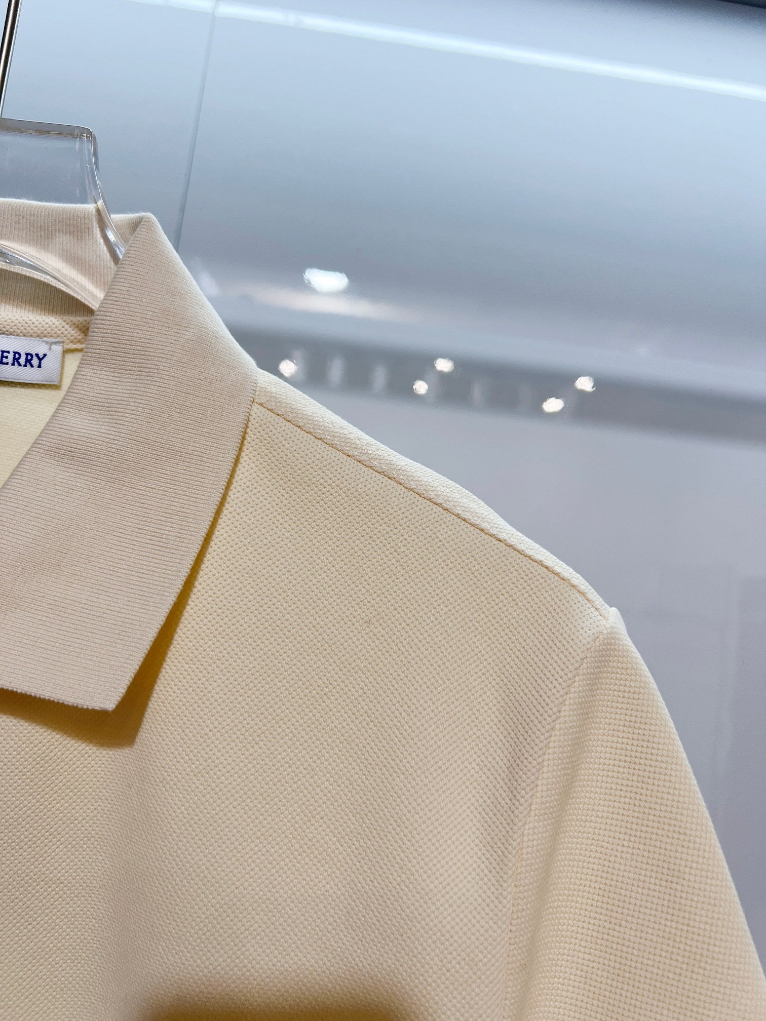 Burberry short-sleeve polo shirt in light cream, shoulder and sleeve seam close-up