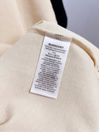 Burberry short-sleeve polo shirt in light cream, care label on inner collar