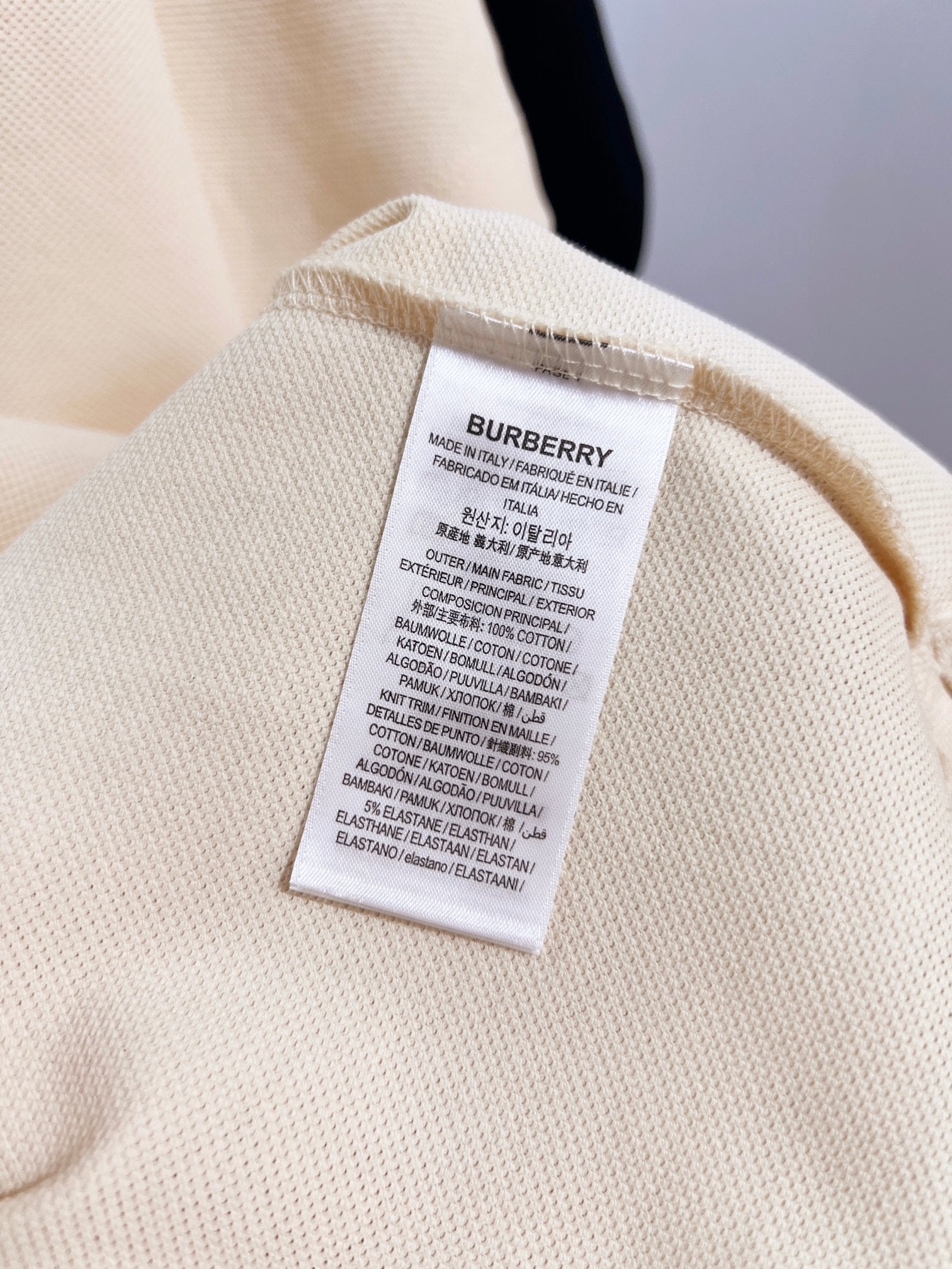 Burberry short-sleeve polo shirt in light cream, care label on inner collar