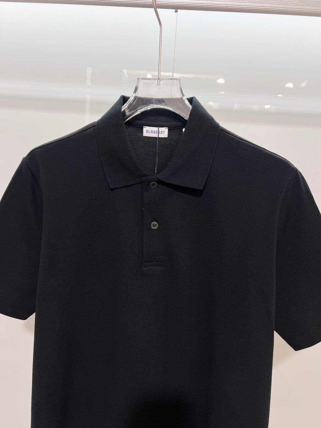 Black polo shirt with buttoned collar and Burberry neck label