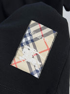Black polo fabric with plaid inner patch showing blue-and-white horse logo