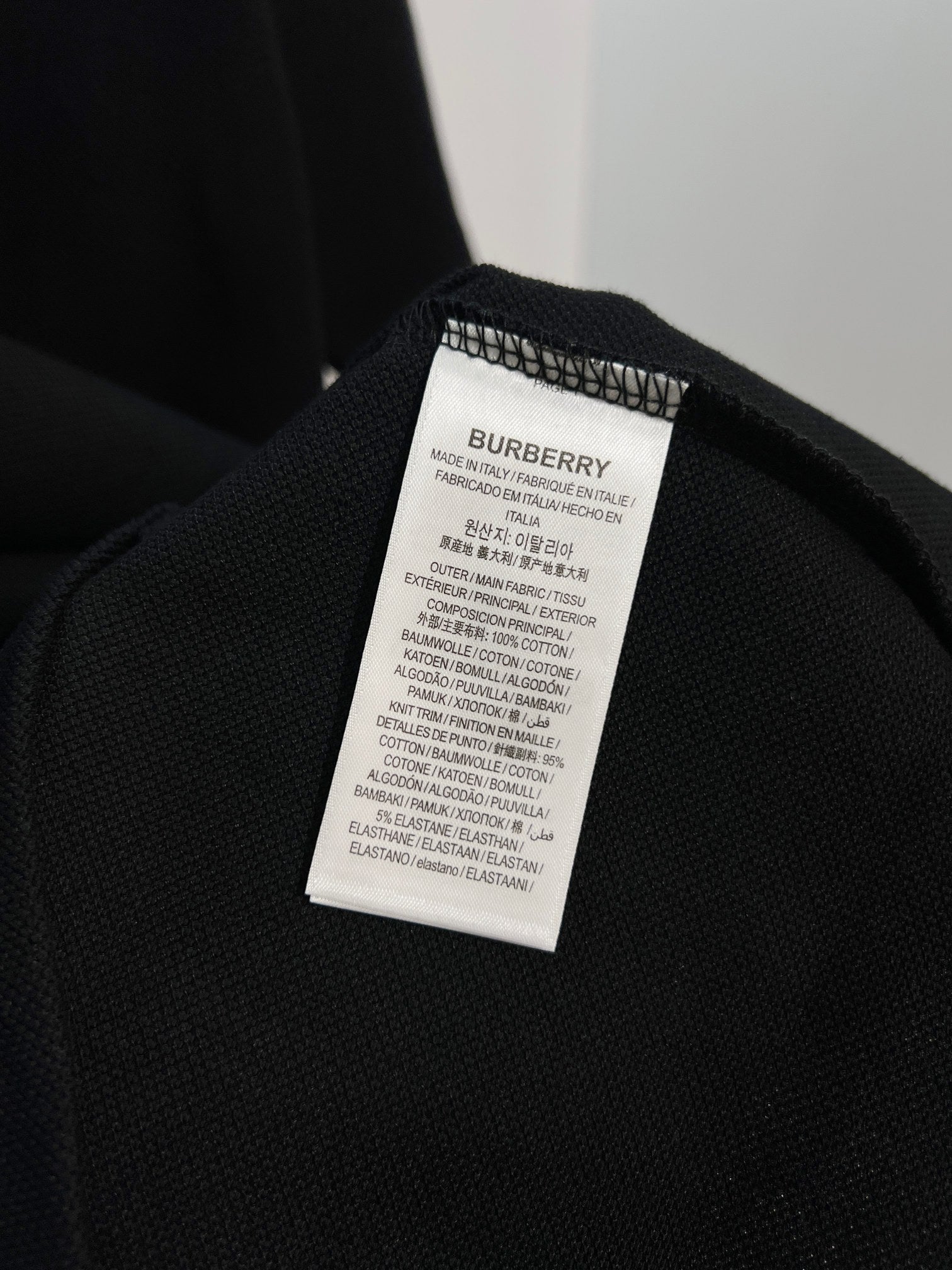 Black polo shirt with care label tag inside collar area