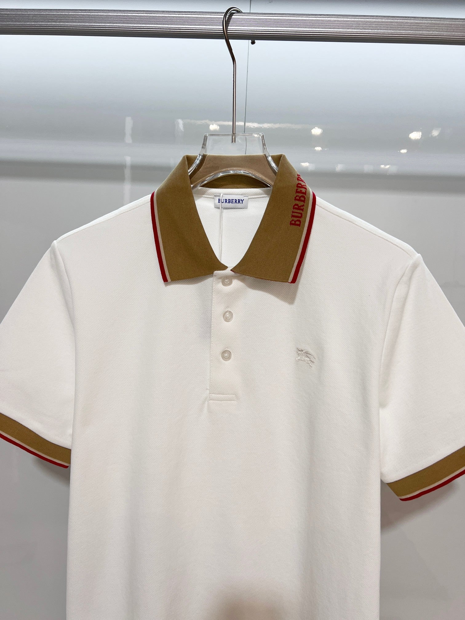 Burberry short-sleeve polo shirt in white with brown fold-over collar and buttons