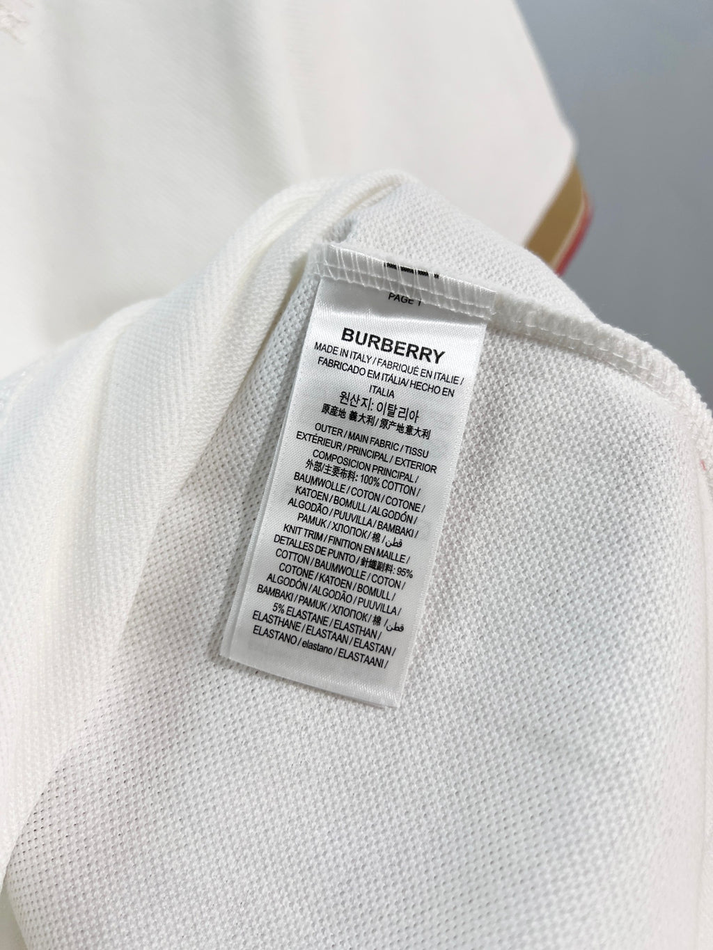 Burberry polo shirt care label inside collar area on white fabric
