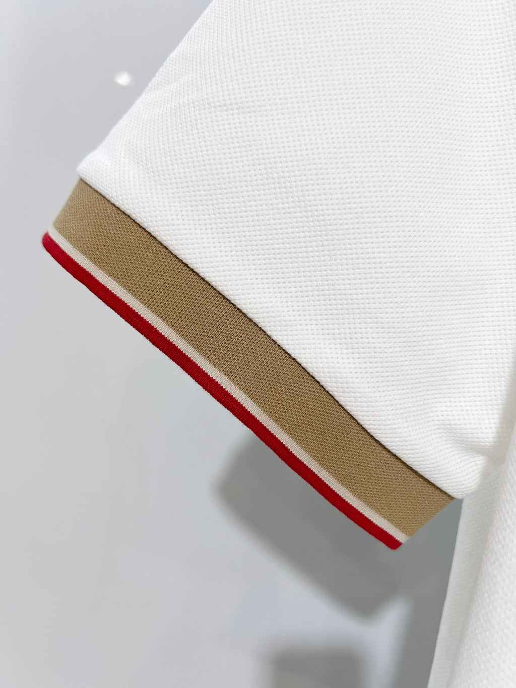 Burberry polo shirt sleeve edge with brown stripe and thin red line