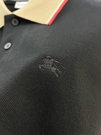 Burberry polo shirt fabric close-up in dark navy with small embroidered logo near chest