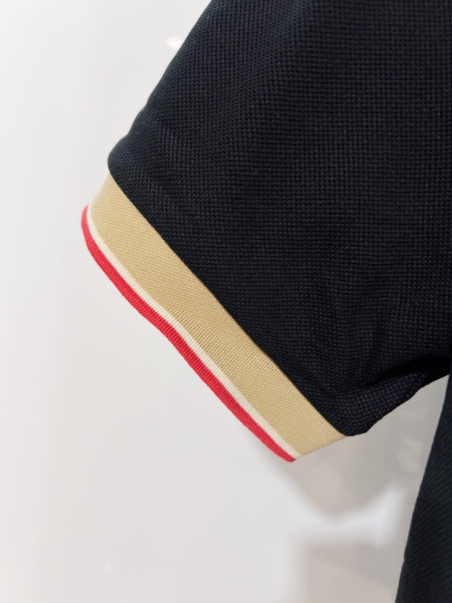 Burberry polo shirt sleeve cuff detail with beige and red striped trim