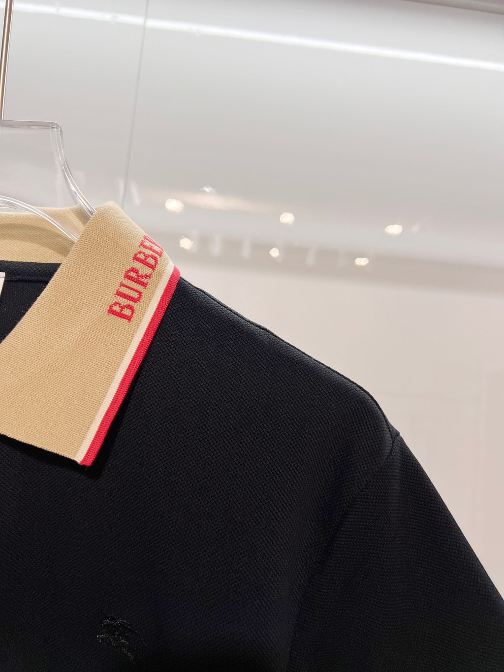 Burberry polo shirt sleeve and collar corner in dark navy with red stripe trim
