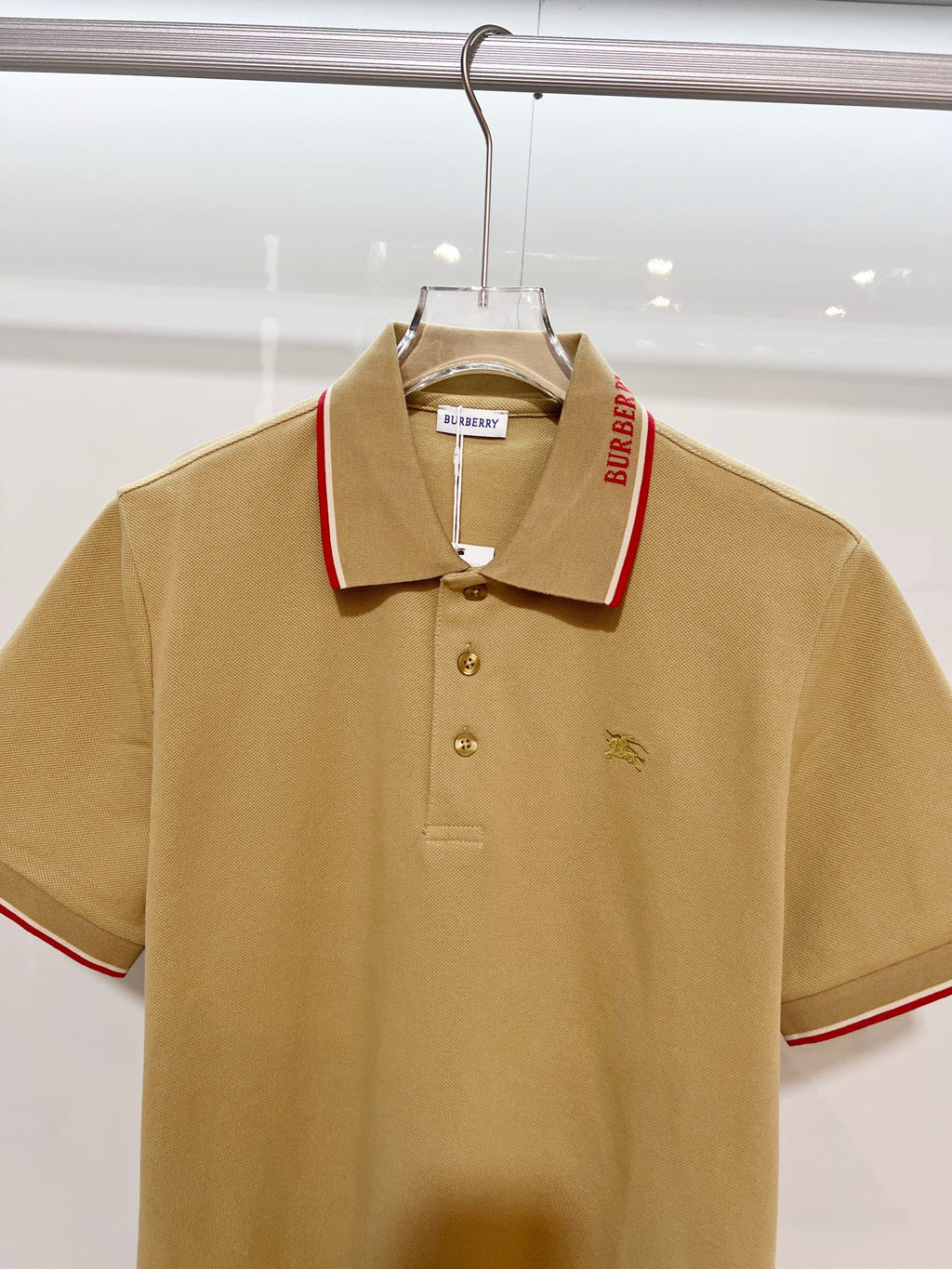 Tan Burberry polo shirt with red-trim collar, 3-button placket, horse logo