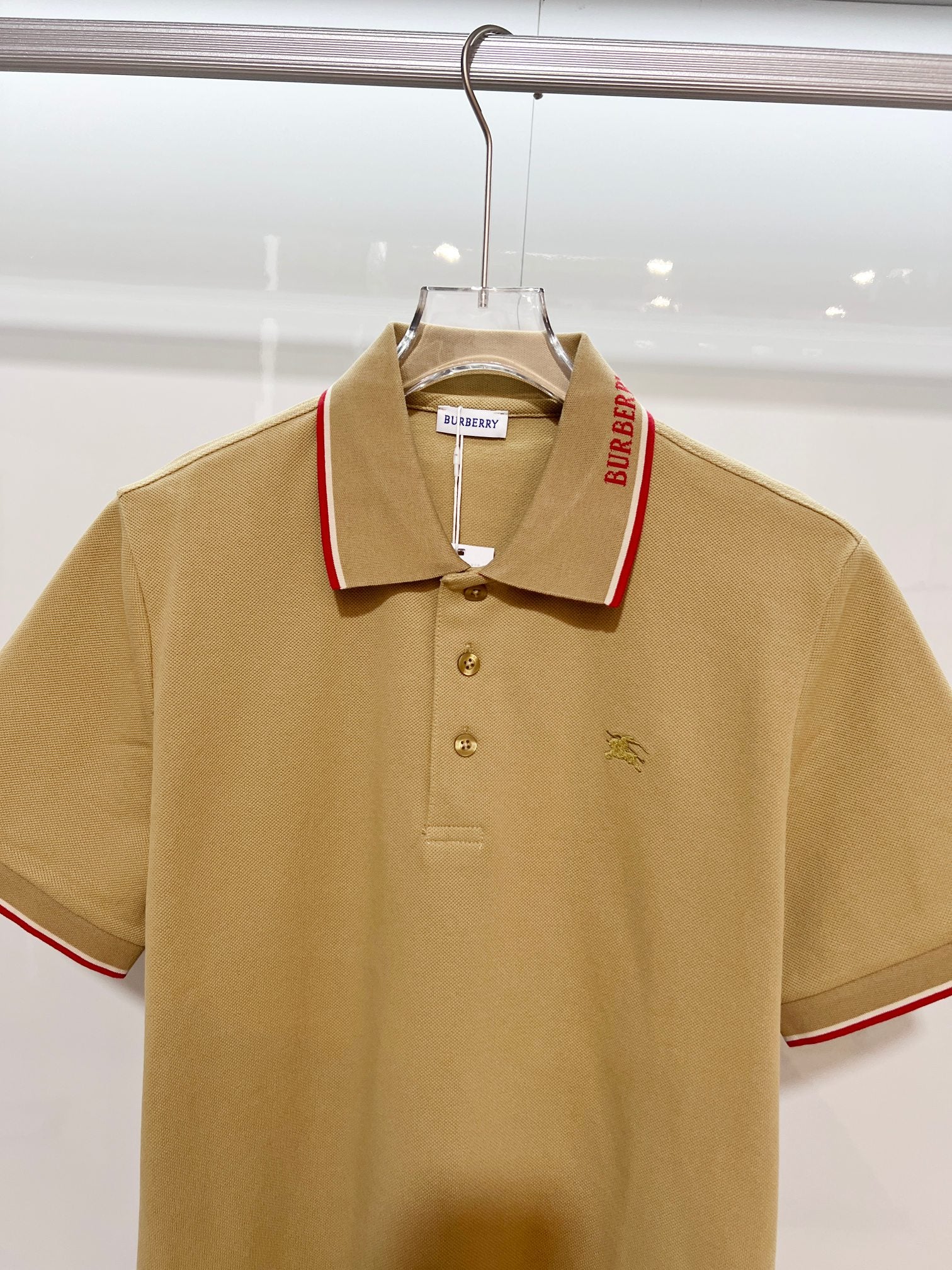 Tan Burberry polo shirt with red-trim collar, 3-button placket, horse logo