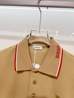 Tan polo shirt front view on hanger with red-trim collar and small horse logo