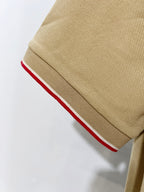 Tan polo shirt sleeve cuff with red-and-white stripe trim